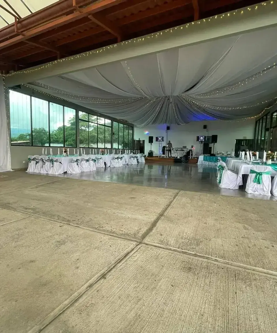 Interior del salón Santa Catalina con telas blancas, luces cálidas y ventanales
