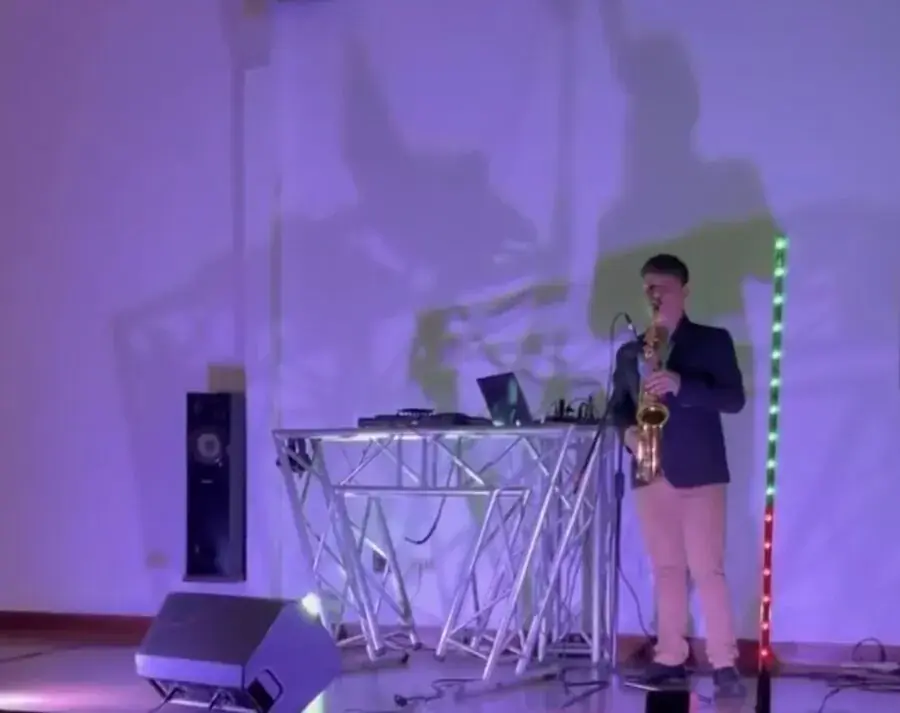 Saxofonista tocando en vivo con luces moradas